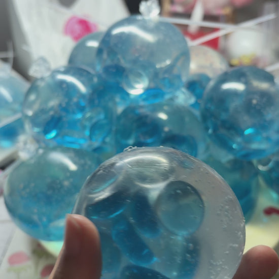 Crystal‑clear handmade squishy packed with shiny aqua flat pebbles. Squeeze and shake with medium force for loud energetic pebble‑collision noise, viral aesthetic stress relief fidget toy.
