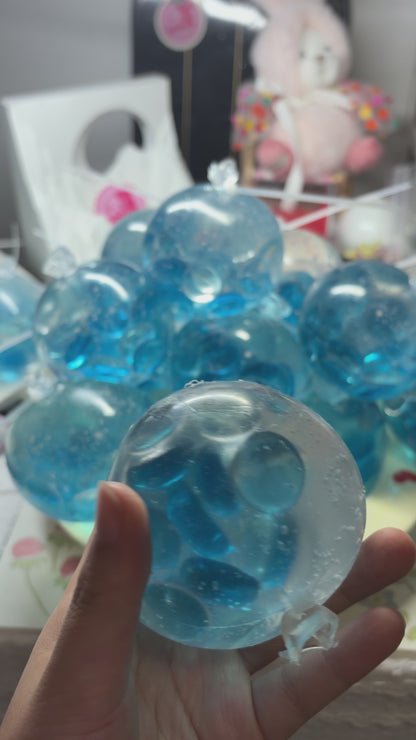 Crystal‑clear handmade squishy packed with shiny aqua flat pebbles. Squeeze and shake with medium force for loud energetic pebble‑collision noise, viral aesthetic stress relief fidget toy.